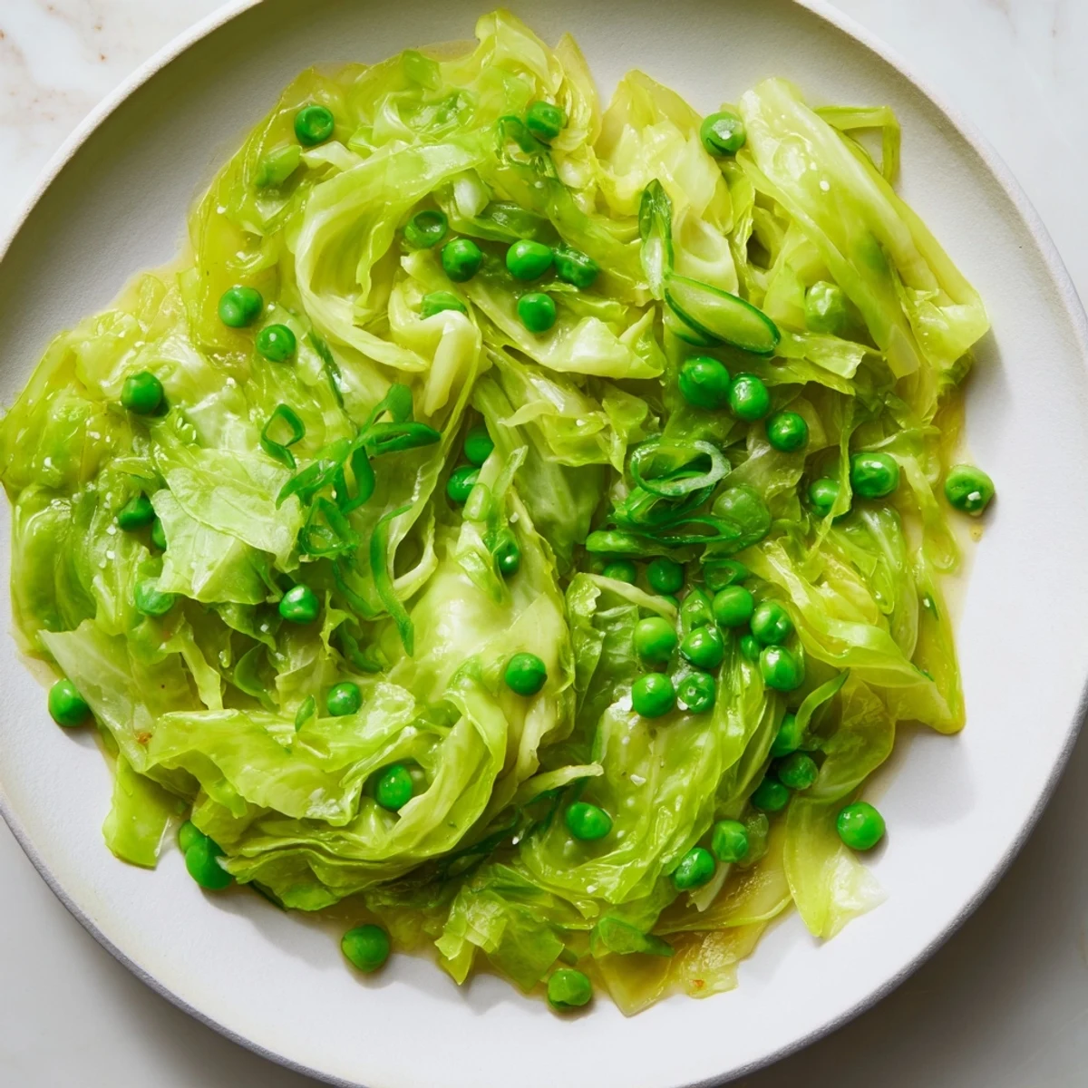 Vibrant plate of cabbage stir-fry with garlic, soy, and peas, offering a quick vegan or vegetarian meal.