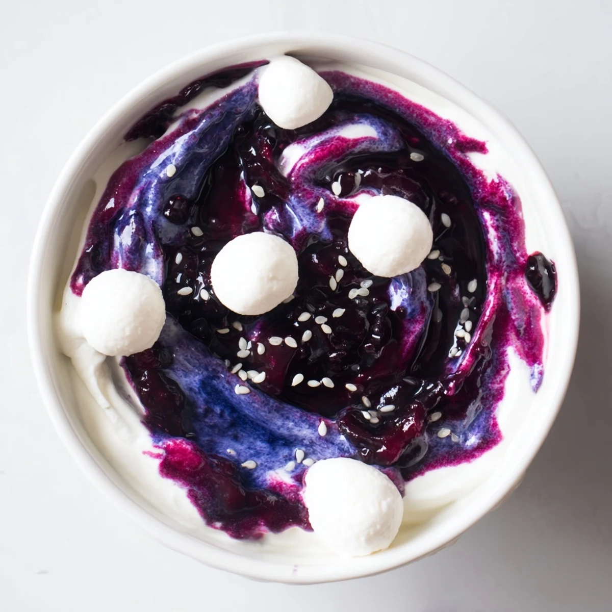 A Galaxy Spiral dessert shows dark berry swirls in yogurt with goat cheese stars sprinkled on top.