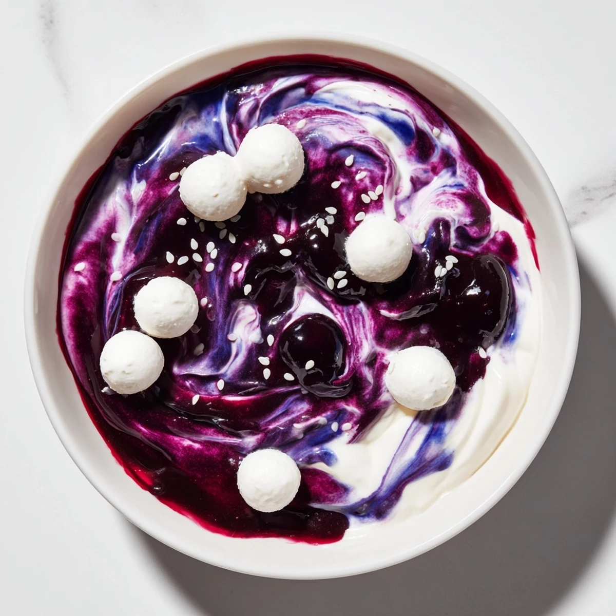 This Galaxy Spiral dessert sparkles with sesame stars and a swirl of dark berry jam, ready to enjoy.