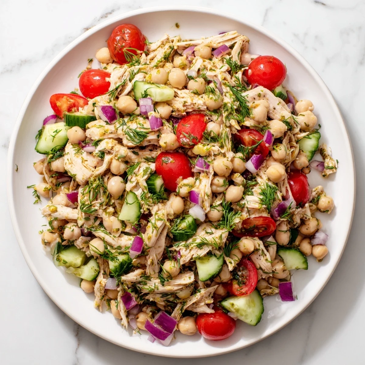 Vibrant Dense Bean Salad with Lemon-Dill Chicken, featuring colorful veggies and shredded chicken in a bright dressing.