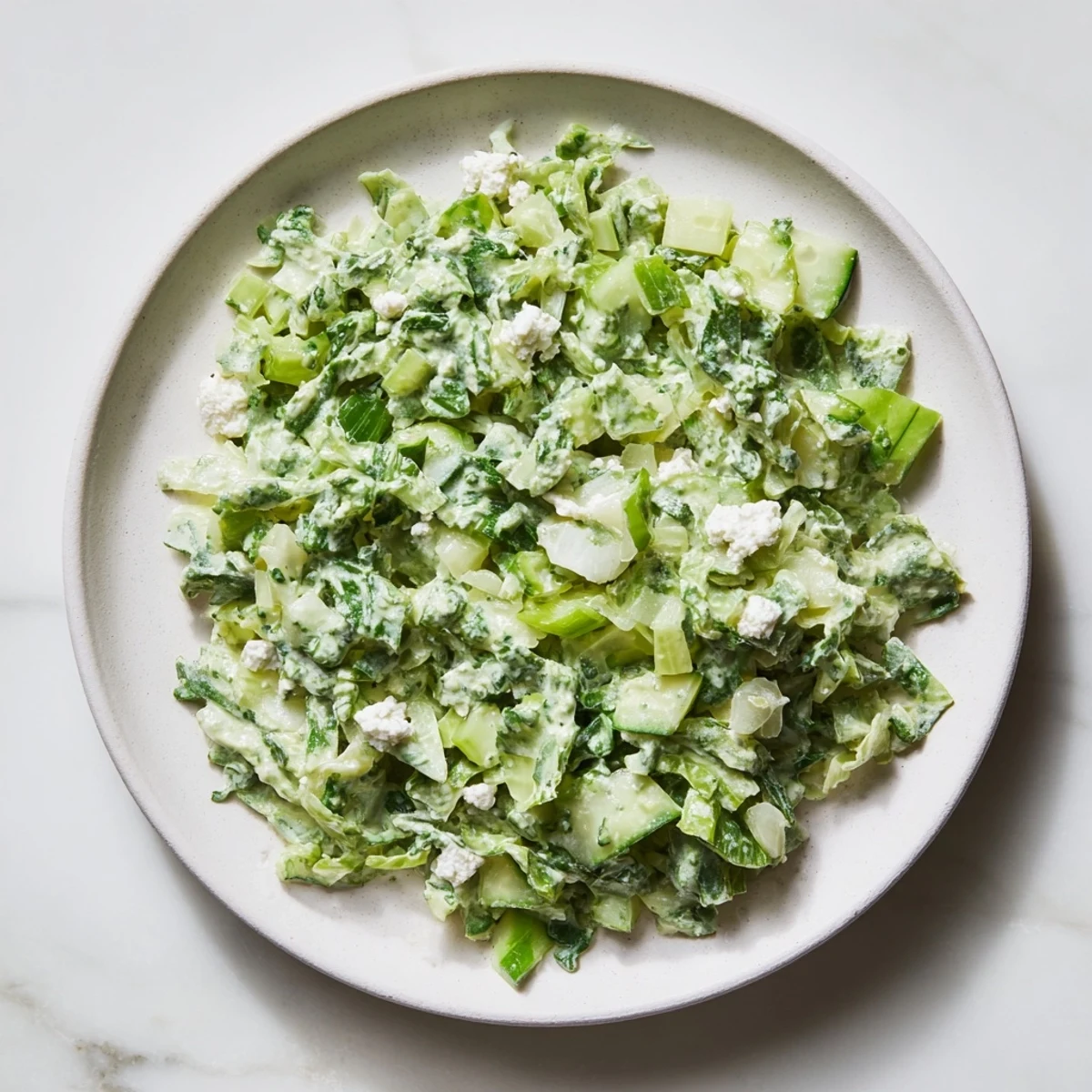 A bowl of colorful, chilled Green Goddess Cabbage Dip, perfect for dipping tortilla chips.