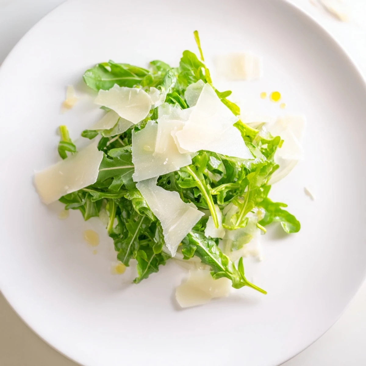 Fresh arugula salad with a bright lemon dressing, Parmesan shavings, and flavorful shallots.