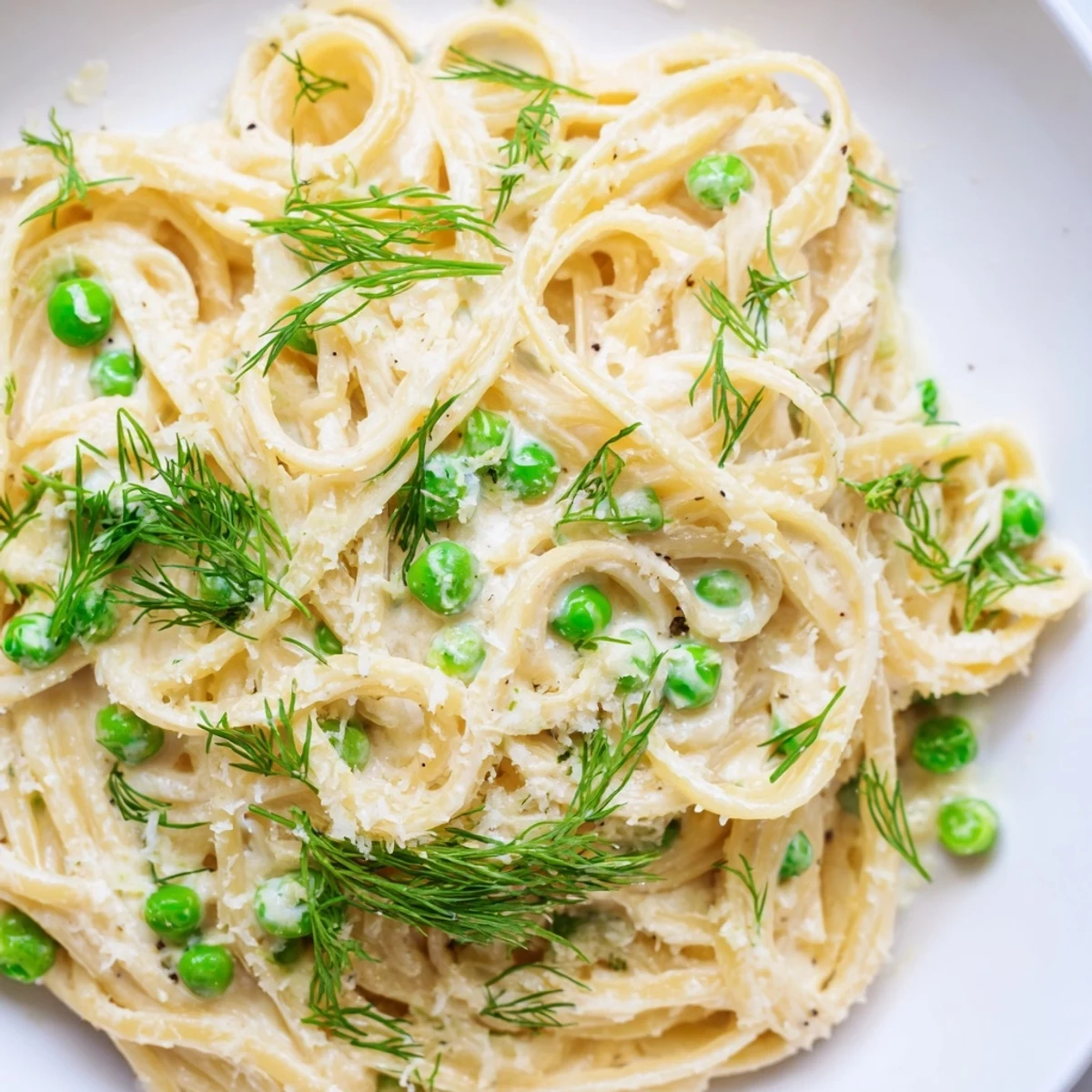Bowl of creamy dill pasta with fresh dill garnish, delicious vegetarian meal.