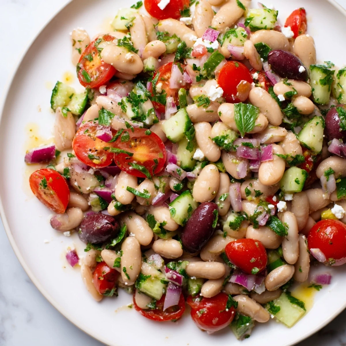Vibrant white bean salad bursting with fresh tomatoes and herbs, drizzled with olive oil dressing.