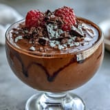 Velvety smooth chocolate mousse made with cottage cheese and Greek yogurt, garnished with chopped nuts for added crunch.