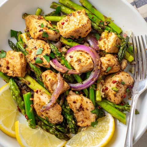 Juicy One-Pan Lemon Garlic Chicken with Asparagus, drizzled in zesty sauce, ready to enjoy.  