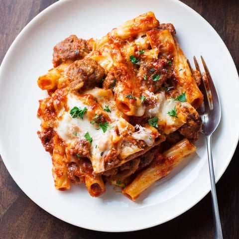 Creamy Baked Ziti with Italian Sausage topped with gooey mozzarella and fresh herbs.