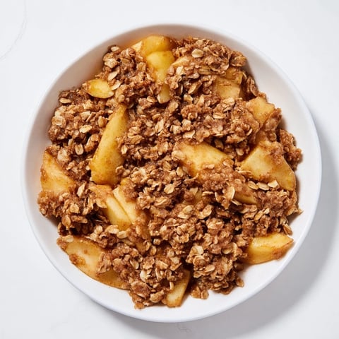 Golden-brown Apple Crisp with a bubbling, warm fruit base, ready to serve with ice cream.