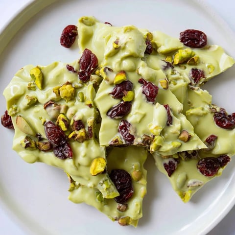 Matcha White Chocolate Cranberry Bark Clusters, a vibrant treat with visible cranberries and pistachios for sharing.