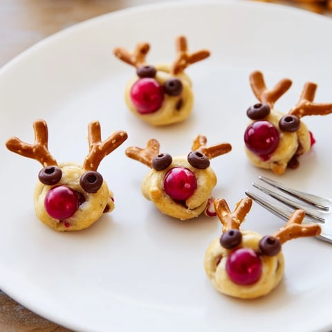 Rudolf's Red Nose Pretzel Bites with cheese and a vibrant red cherry nose are a festive appetizer.