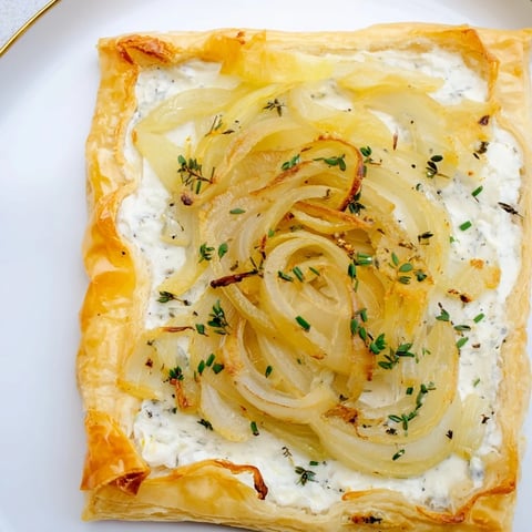 Golden, bubbly Caramelized Onion Tart—a rustic French delight ready for a satisfying, savory bite.