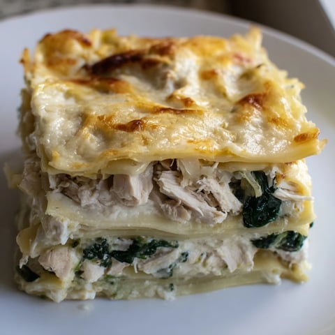 Golden-brown Chicken Alfredo Lasagna slices reveal creamy layers of tender chicken, spinach, and melted mozzarella.