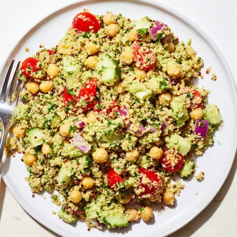 Refreshing quinoa salad with chickpeas and avocado dressing, garnished with parsley.  