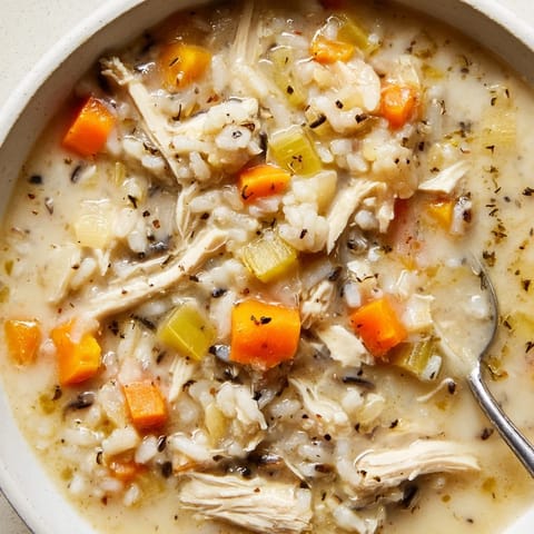 Creamy Chicken and Wild Rice Soup steaming in a bowl, garnished with fresh parsley.