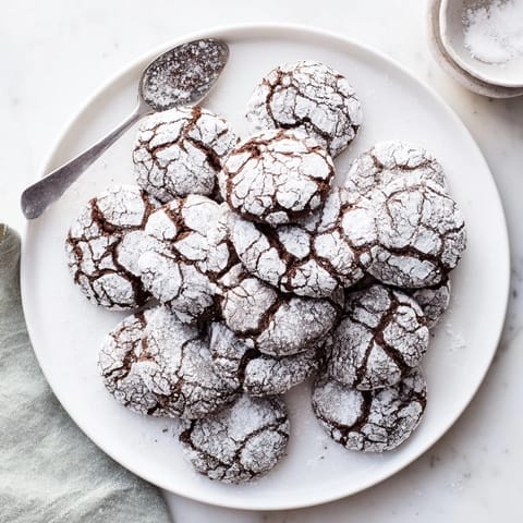 A close-up of crackled Chocolate Crinkle Cookies, showcasing their soft, fudgy, and delicious texture.