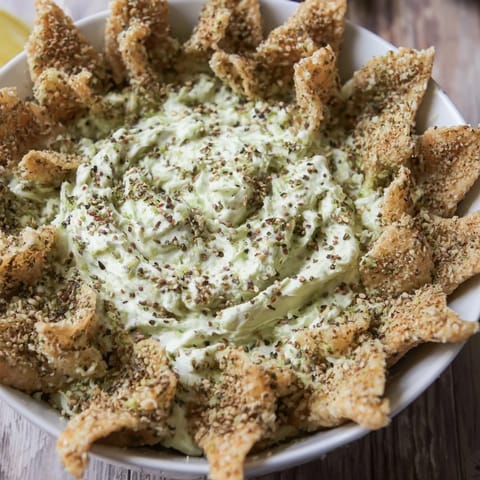 Festive star-shaped pesto dip with golden, crispy cracker edges, perfect for a party.