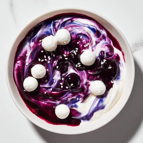 This Galaxy Spiral dessert sparkles with sesame stars and a swirl of dark berry jam, ready to enjoy.