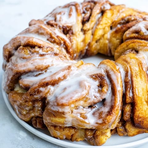 Warm, gooey Cinnamon Roll Pull-Apart Wreath with a sweet vanilla glaze drizzled over the top.