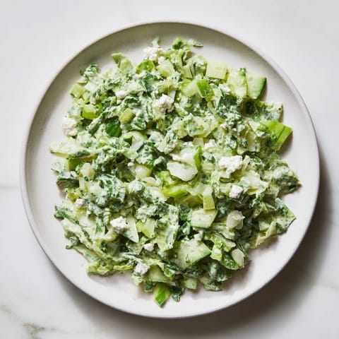 A bowl of colorful, chilled Green Goddess Cabbage Dip, perfect for dipping tortilla chips.
