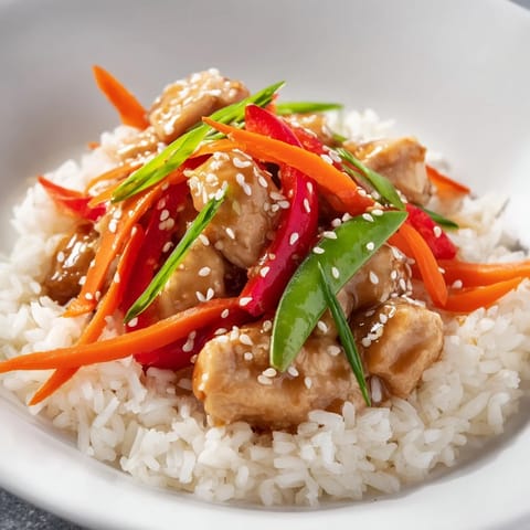 The vibrant colors of the Sesame Ginger Rice Bowl shine through—chicken, rice, and crisp vegetables.