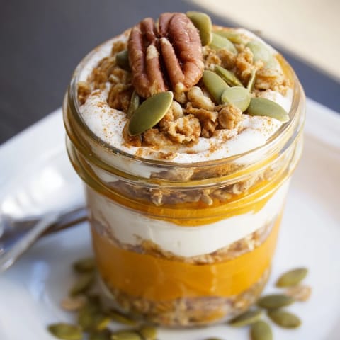 Pumpkin Yogurt Parfait: see the vibrant orange pumpkin layers and crunchy granola in a jar.