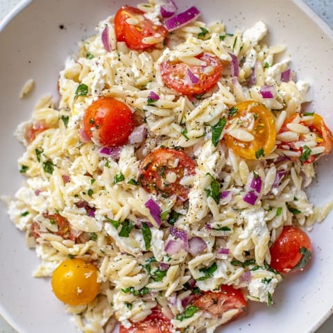 Bright, juicy cherry tomatoes and creamy feta cheese star in this refreshing Tomato Feta Orzo salad.