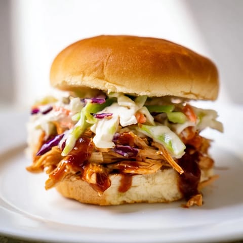 Tender pulled BBQ chicken sliders with tangy slaw and soft buns, perfect for game day gatherings.