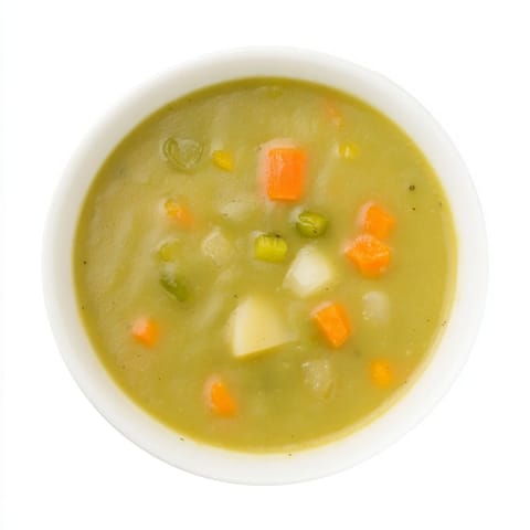 Split pea soup, thick and velvety, garnished with fresh herbs in a cozy kitchen scene.