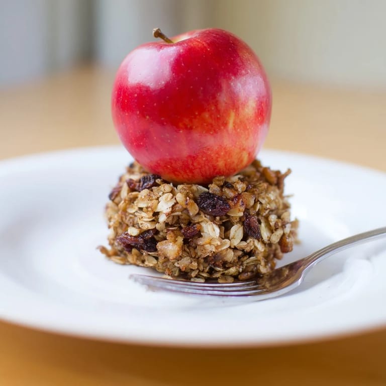Steaming-hot, tender Baked Apples with Oat-Nut Crumble, served with a scoop of yogurt.