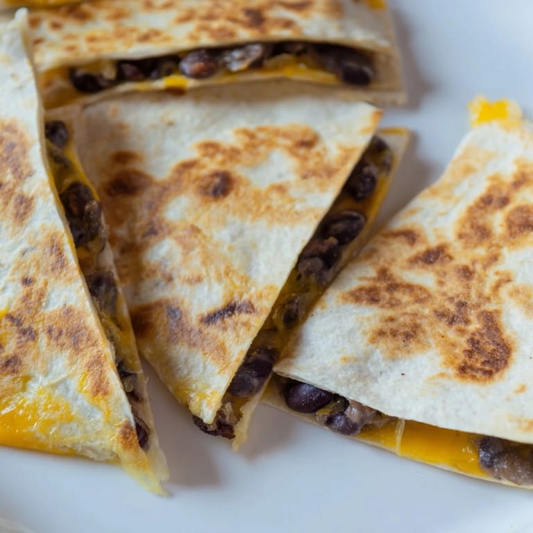 Freshly made Bean & Cheese Quesadillas, a quick and easy vegetarian meal with melty cheese and flavorful beans.