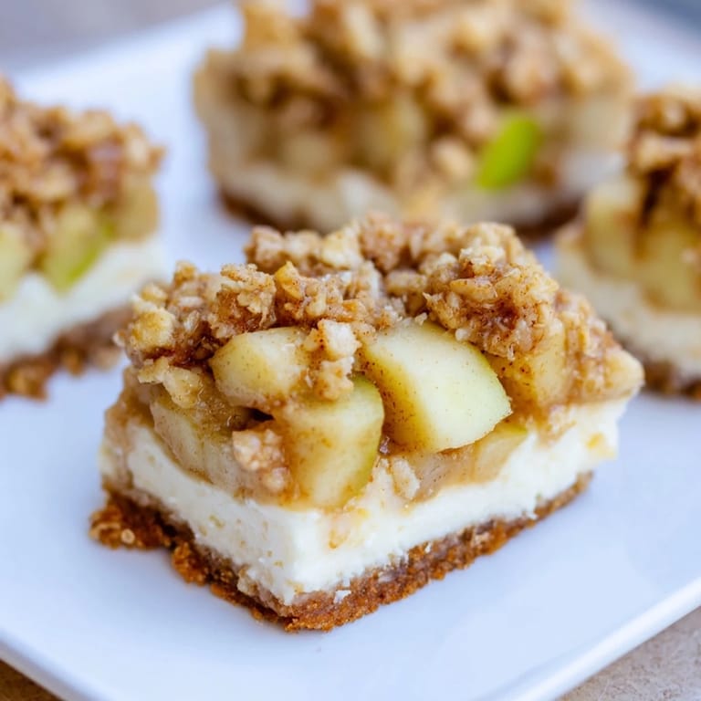 Sliced Apple Crisp Cheesecake Bars showcasing a perfect balance of textures, ready to enjoy with a bite.