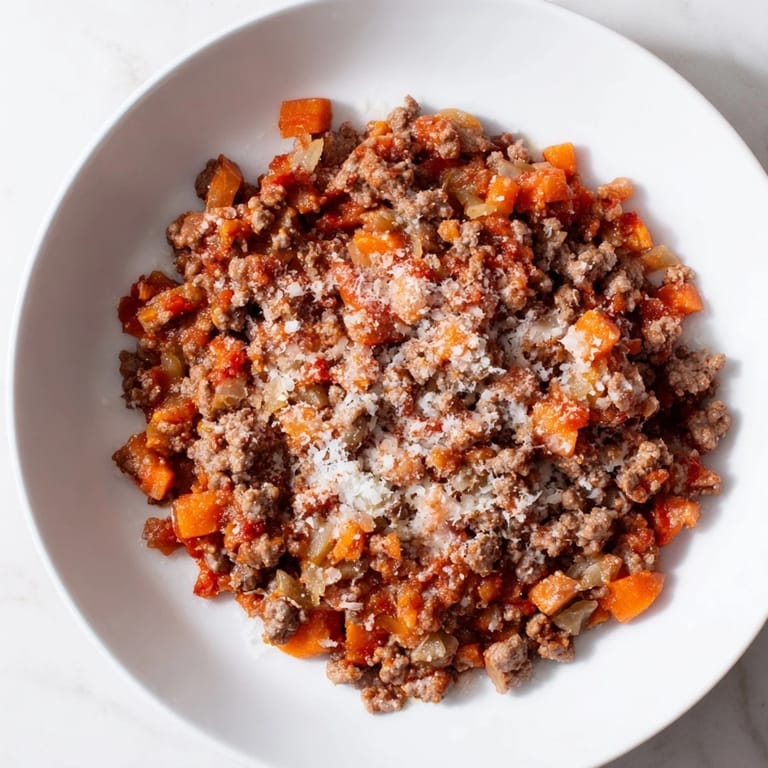 Close-up of a bubbling Classic Tuscan Ragu; the savory aroma of slow-cooked meat and tomatoes.
