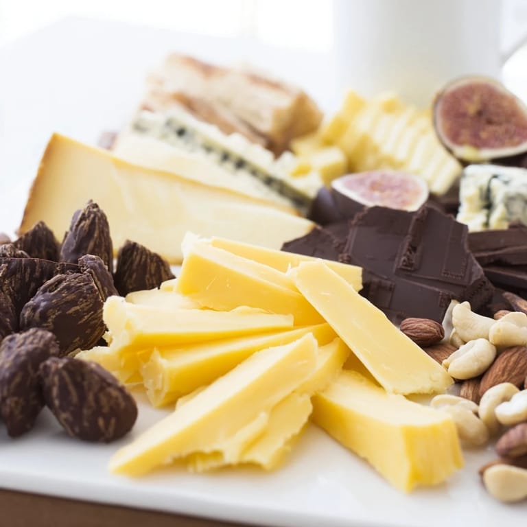 Dark chocolate melting into creamy, warm Fireside Comfort & Cocoa alongside aged cheeses.