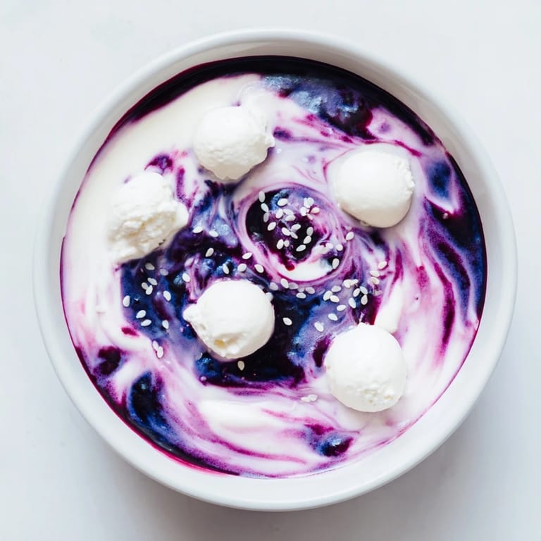 See a stunning Galaxy Spiral dessert: creamy yogurt swirled with jam and goat cheese, garnished with sesame.