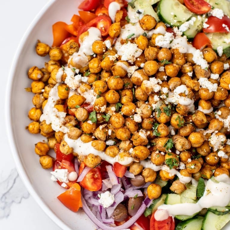 A colorful Mediterranean Chickpea Bowl featuring golden, crispy chickpeas alongside fresh, chopped vegetables.