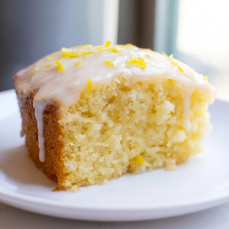A slice of moist Lemon Yogurt Cake, offering a delightful combination of tart and sweet flavors.