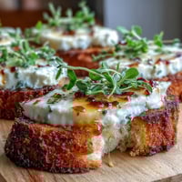 Crisp, golden crostini slices topped with creamy goat cheese and a glossy drizzle of hot honey.